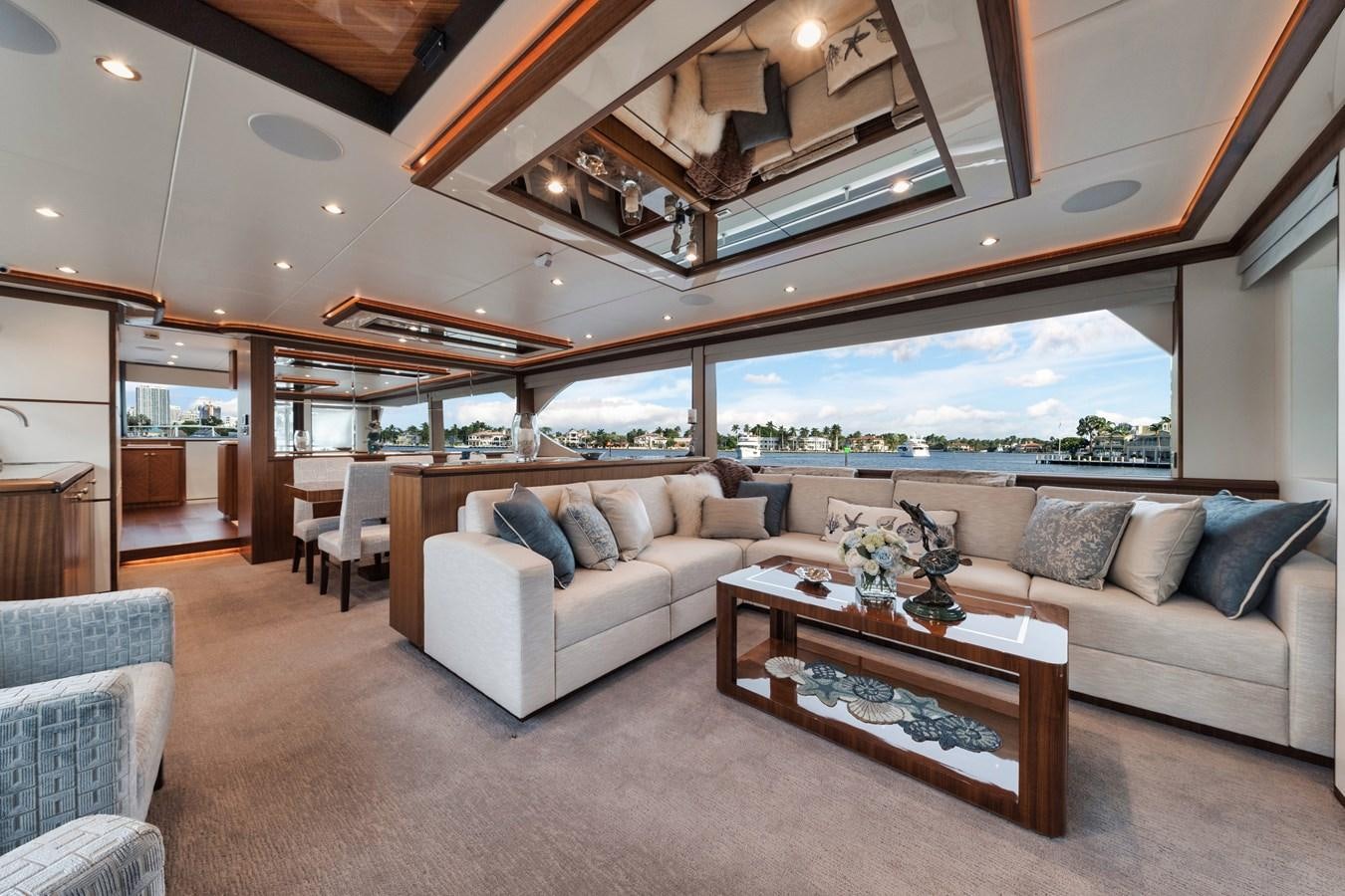 a living room with a large window aboard 2019 OCEAN ALEXANDER 88 SKYLOUNGE MUDSLINGER Yacht for Sale
