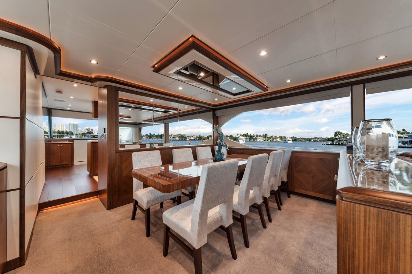 a room with tables and chairs aboard 2019 OCEAN ALEXANDER 88 SKYLOUNGE MUDSLINGER Yacht for Sale