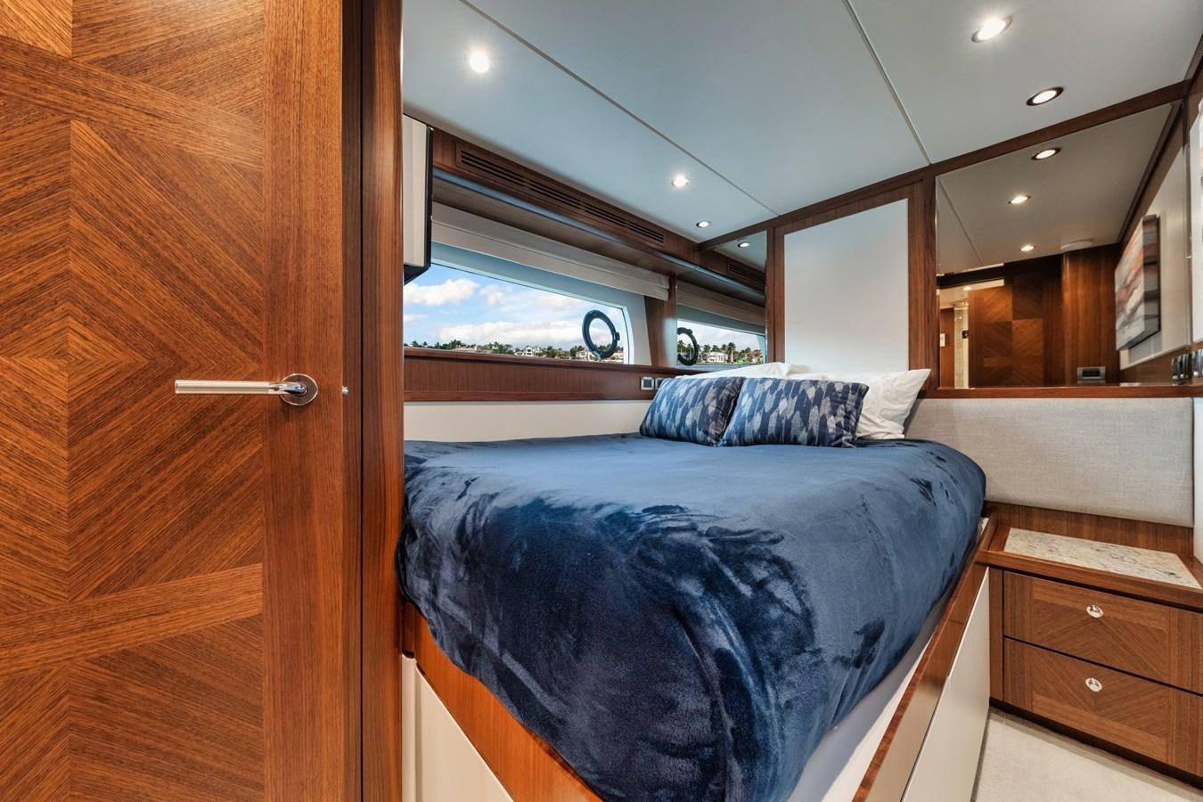 a bedroom with a bed and a closet aboard 2019 OCEAN ALEXANDER 88 SKYLOUNGE MUDSLINGER Yacht for Sale