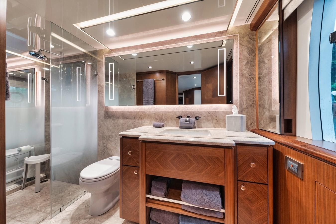 a bathroom with a large mirror aboard 2019 OCEAN ALEXANDER 88 SKYLOUNGE MUDSLINGER Yacht for Sale