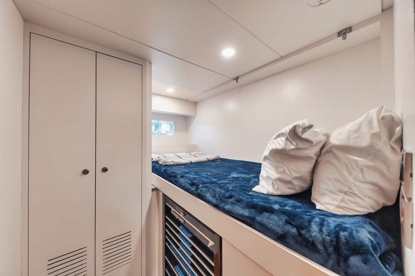 a bedroom with a bed and a closet aboard 2019 OCEAN ALEXANDER 88 SKYLOUNGE MUDSLINGER Yacht for Sale