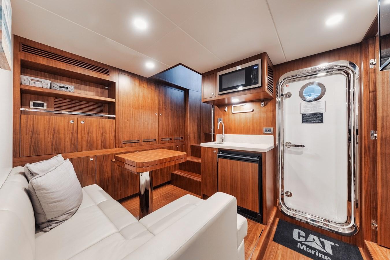 a room with a bed and a refrigerator aboard 2019 OCEAN ALEXANDER 88 SKYLOUNGE MUDSLINGER Yacht for Sale