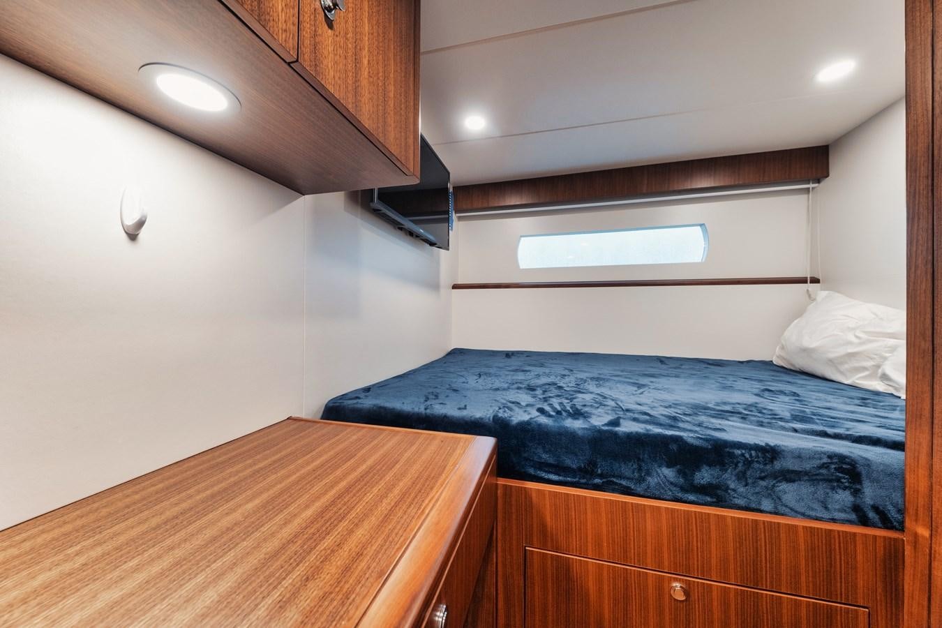 a bed with a blue blanket aboard 2019 OCEAN ALEXANDER 88 SKYLOUNGE MUDSLINGER Yacht for Sale