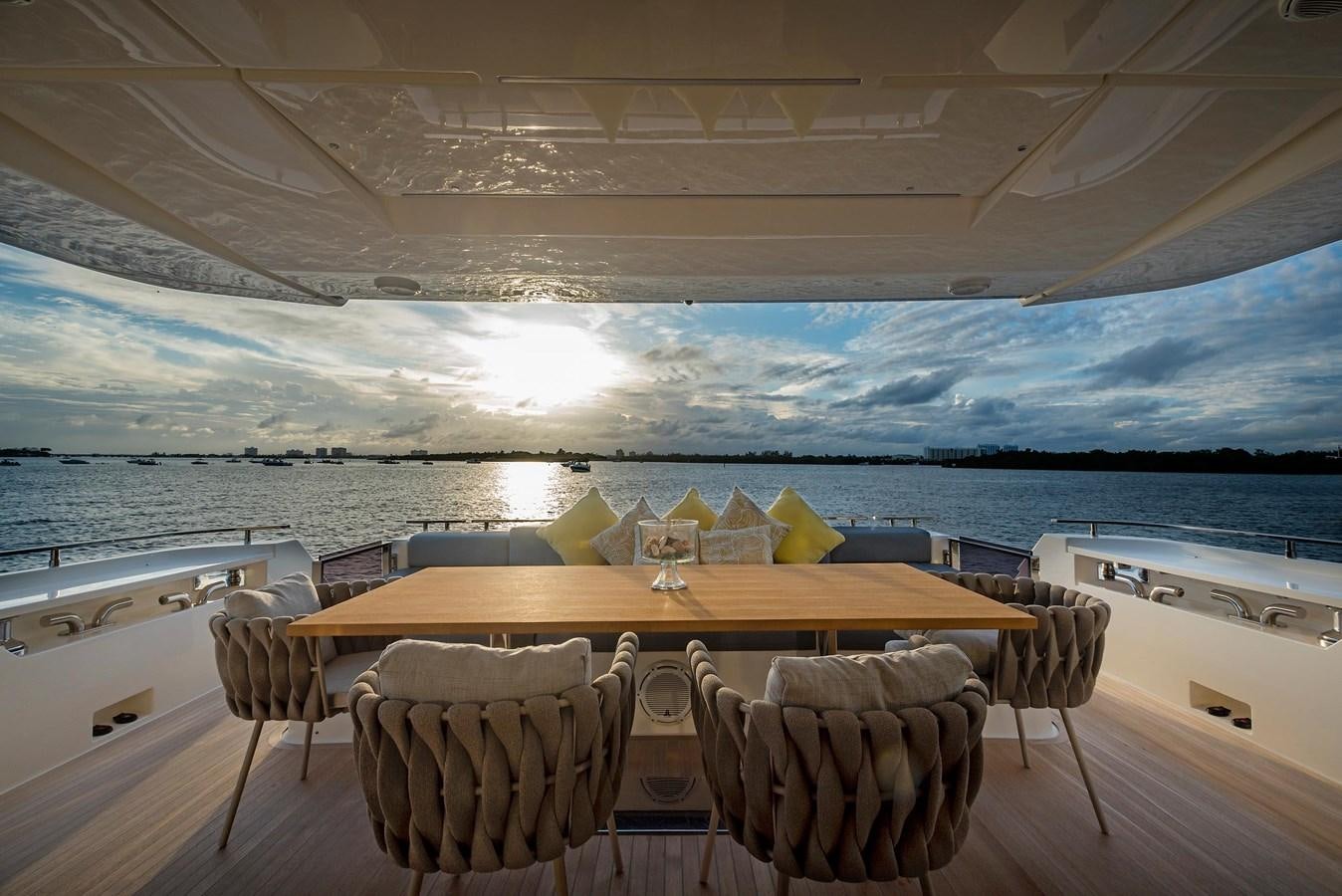 a table and chairs on a balcony overlooking a body of water aboard LA MARTINA Yacht for Sale