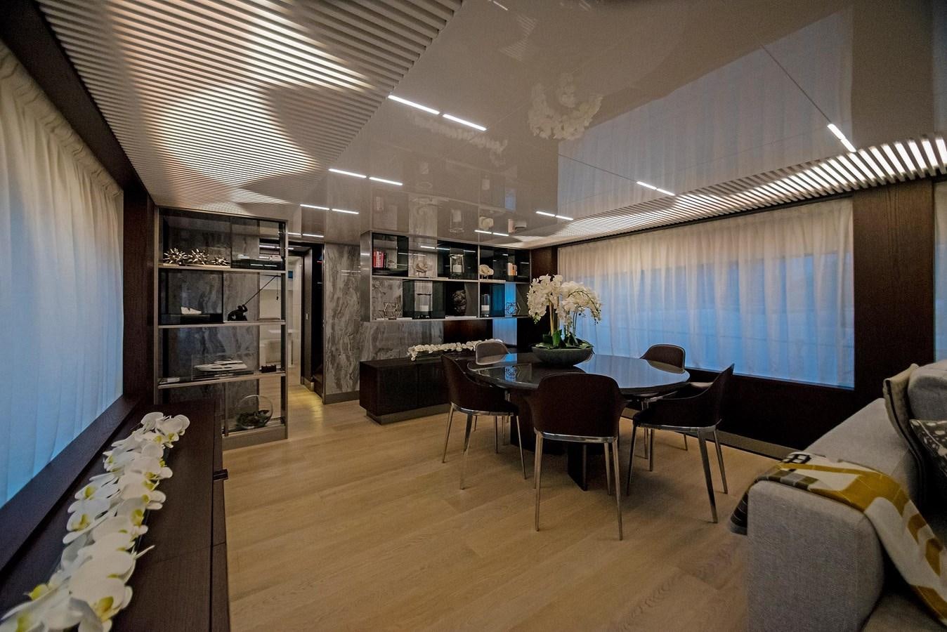 a room with a table chairs and a bookcase aboard LA MARTINA Yacht for Sale