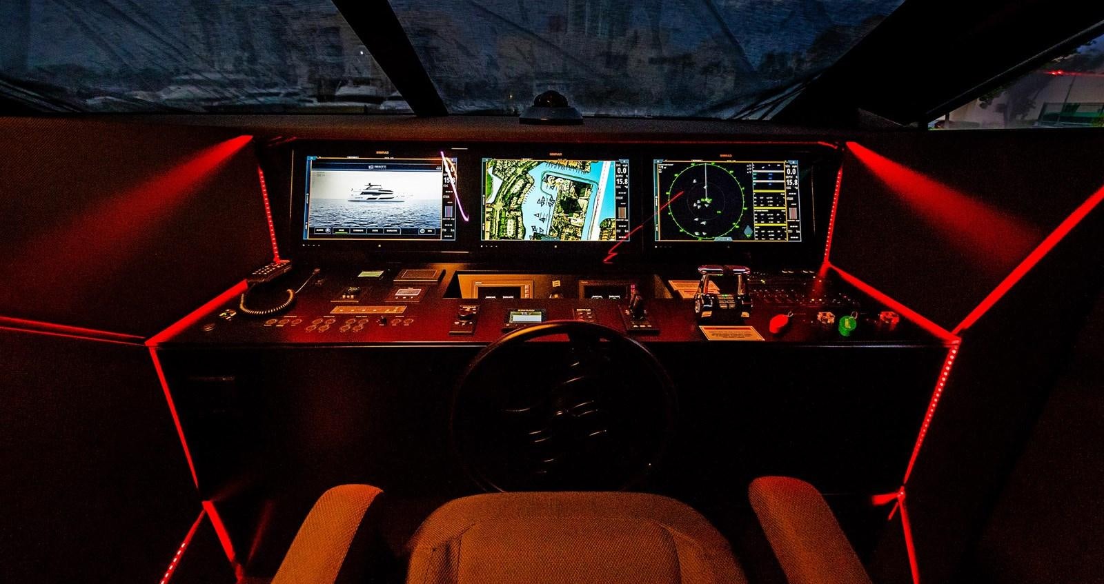 a cockpit with a black steering wheel and red seats aboard LA MARTINA Yacht for Sale