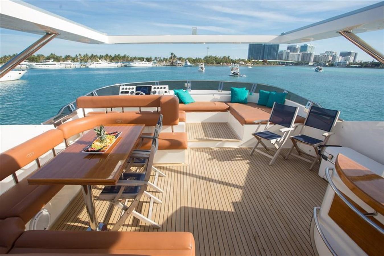 a deck with chairs and tables on it by a body of water aboard BLUOCEAN Yacht for Sale
