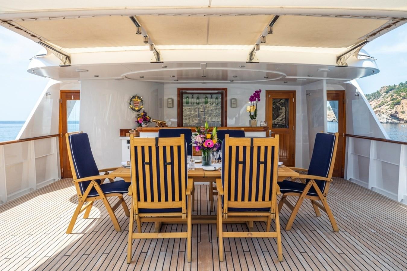 a dining table on a deck aboard MONACO Yacht for Sale