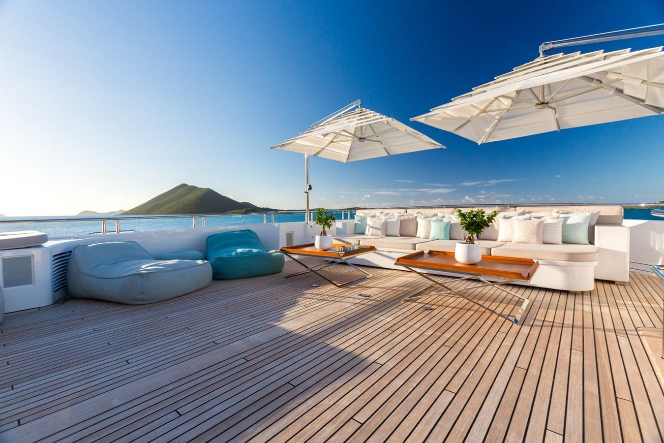 a deck with a pool and lounge chairs on it aboard ADVENTURE Yacht for Sale