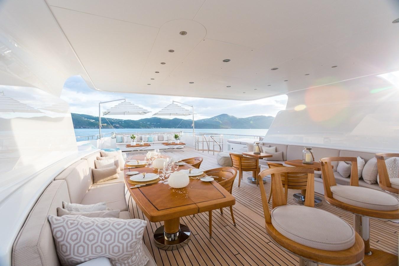 a room with a table chairs and a view of the water aboard ADVENTURE Yacht for Sale