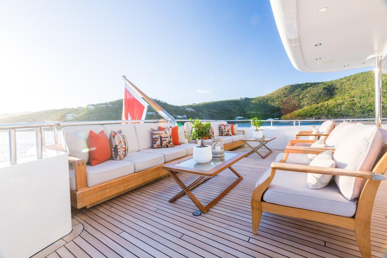 a deck with a table and chairs aboard ADVENTURE Yacht for Sale