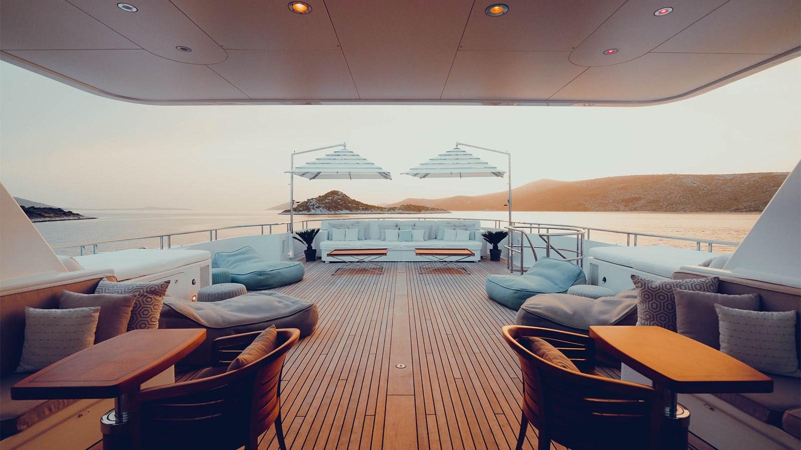 a large room with a large lounge area and a large boat in the background aboard ADVENTURE Yacht for Charter