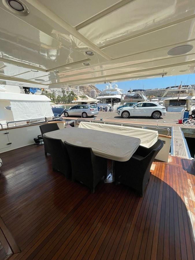 a table with a chair and a car parked in the background aboard LIBERATA Yacht for Sale