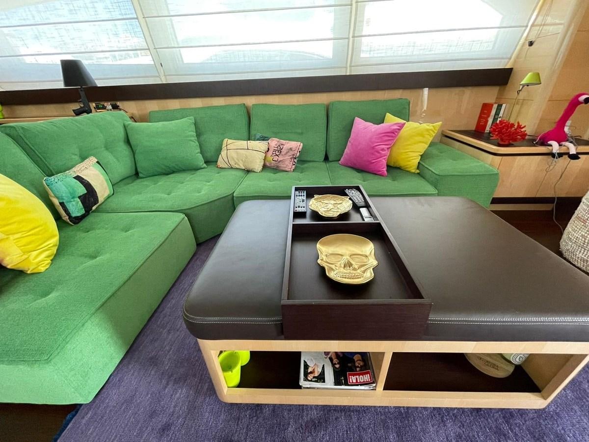 a green couch with a coffee table aboard LIBERATA Yacht for Sale
