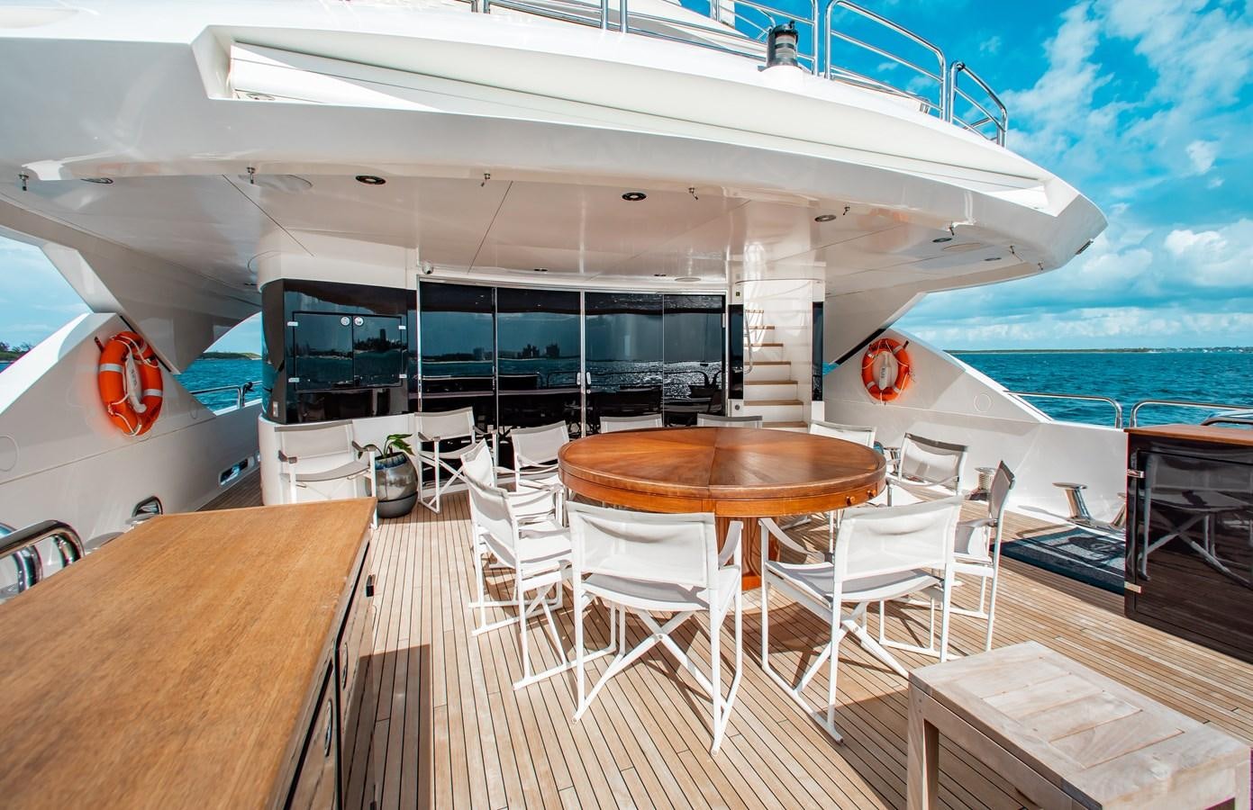 a deck with tables and chairs on it next to a large body of water aboard MARIN Yacht for Sale