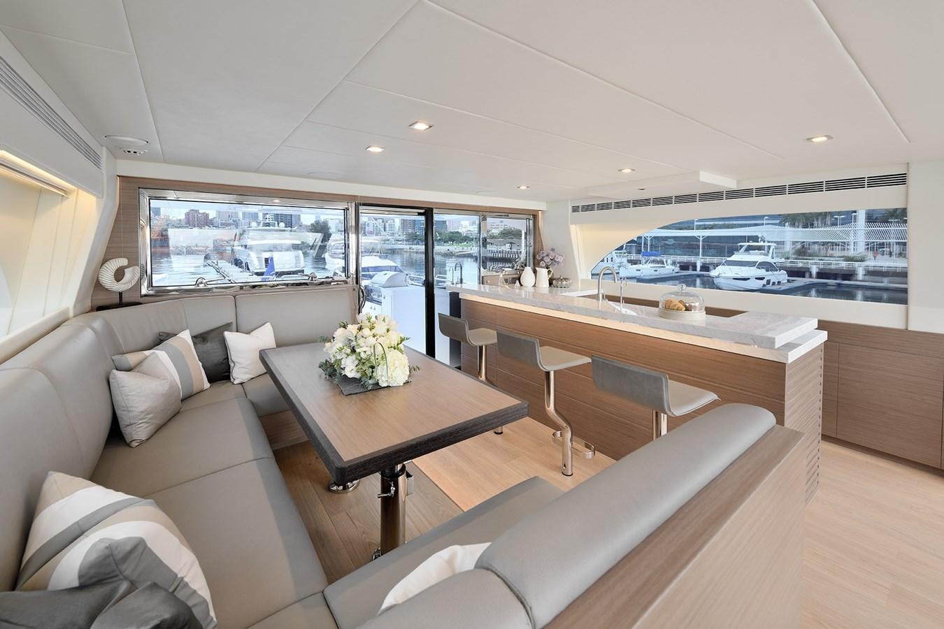 a living room with a table and couches aboard E81 Yacht for Sale