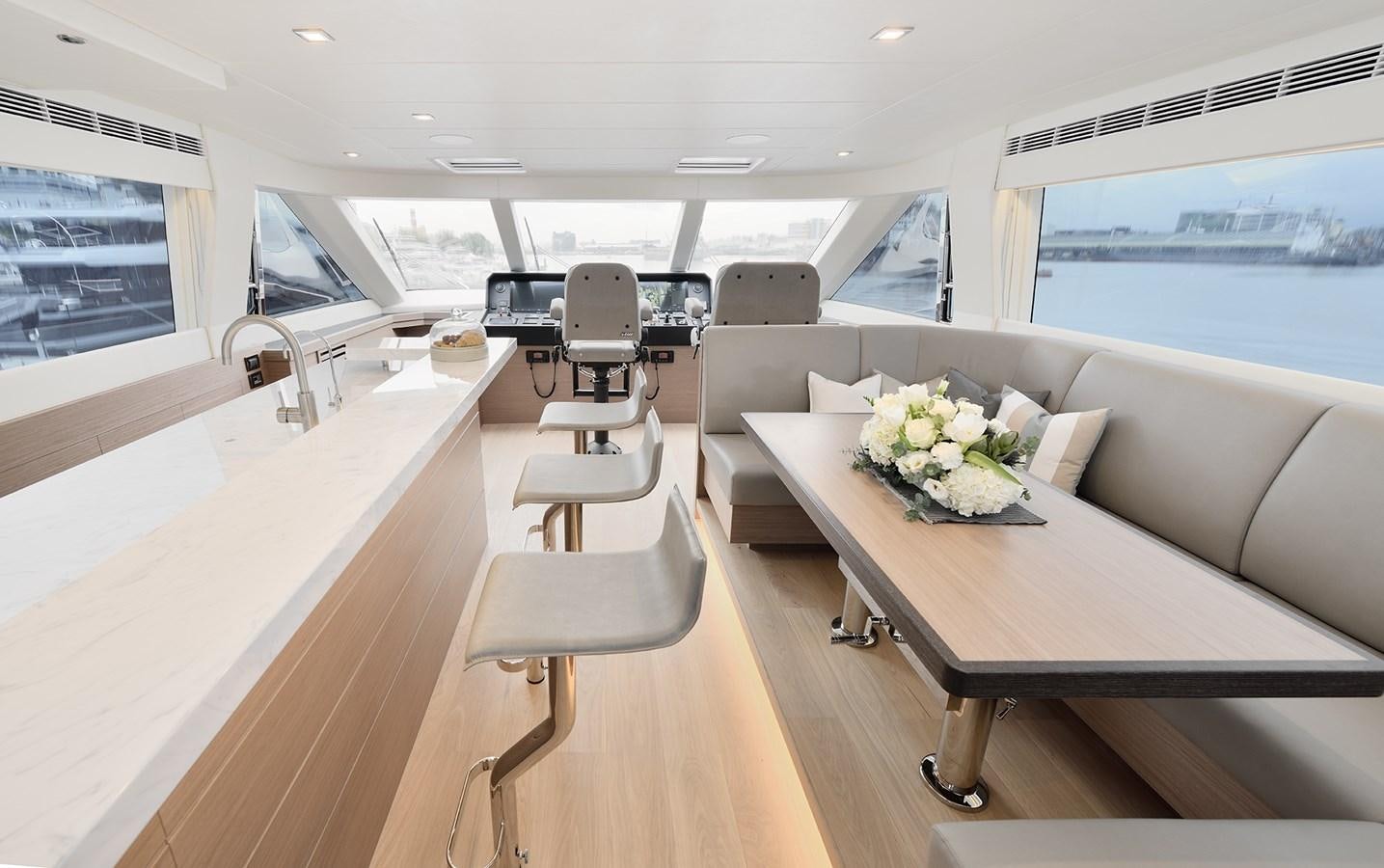 a room with a table chairs and flowers on the table aboard E81 Yacht for Sale