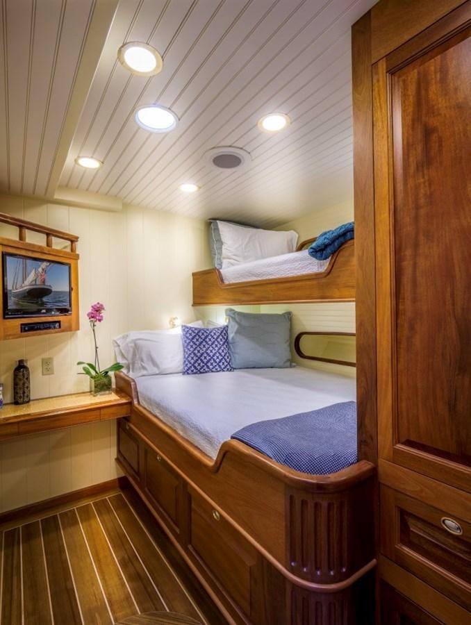a bedroom with a bed and a television aboard COLUMBIA Yacht for Charter