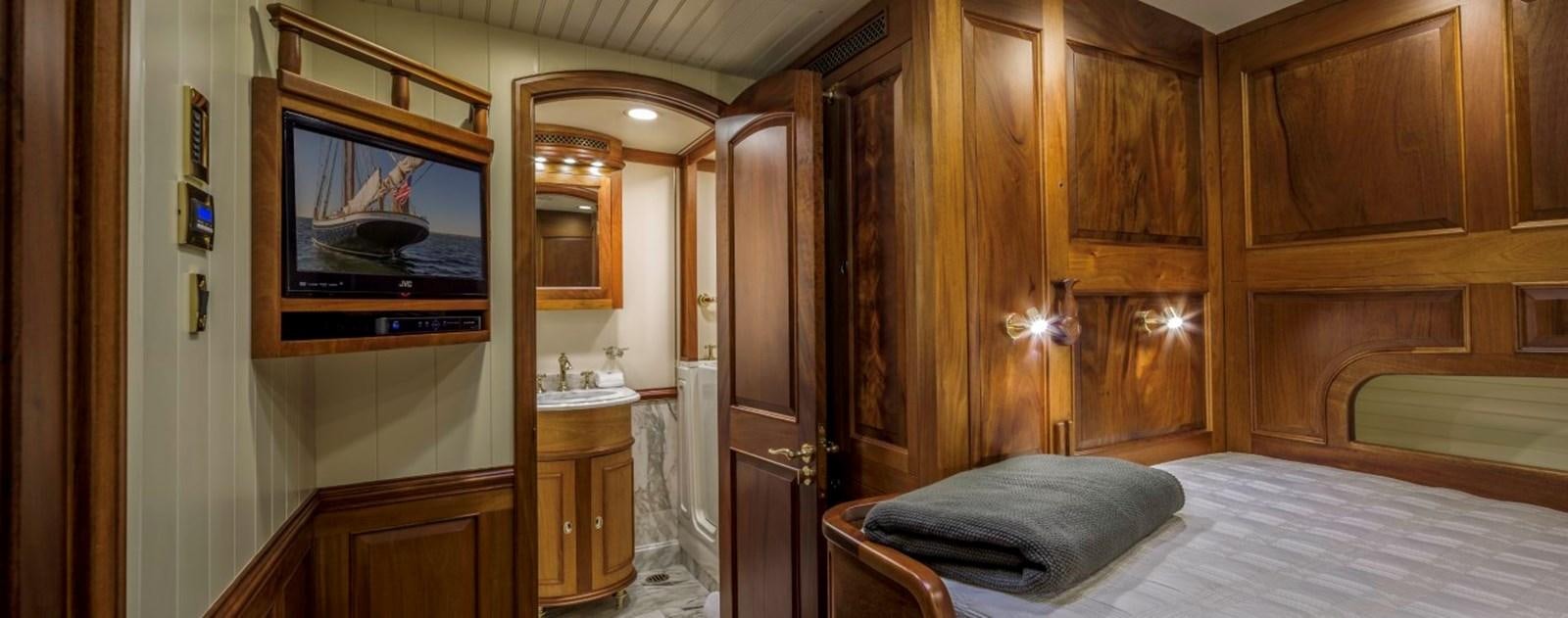 a bedroom with a bed and a television aboard COLUMBIA Yacht for Charter