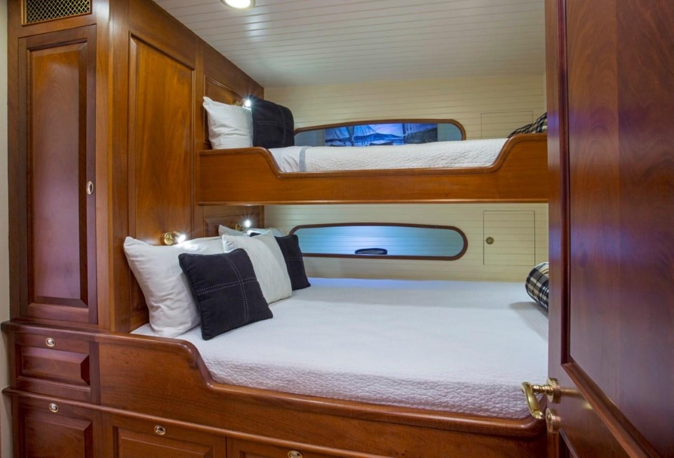 a bed with a white sheet and pillows aboard COLUMBIA Yacht for Charter