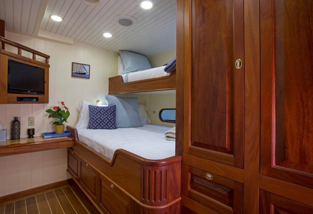 a bedroom with a bed and a television aboard COLUMBIA Yacht for Charter