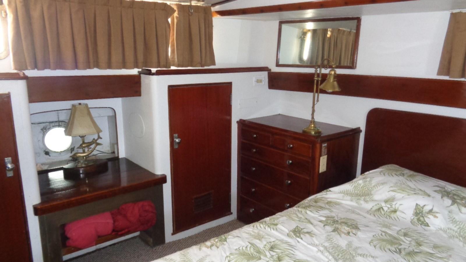 a bedroom with a bed and a desk aboard LION'S WHELP Yacht for Sale
