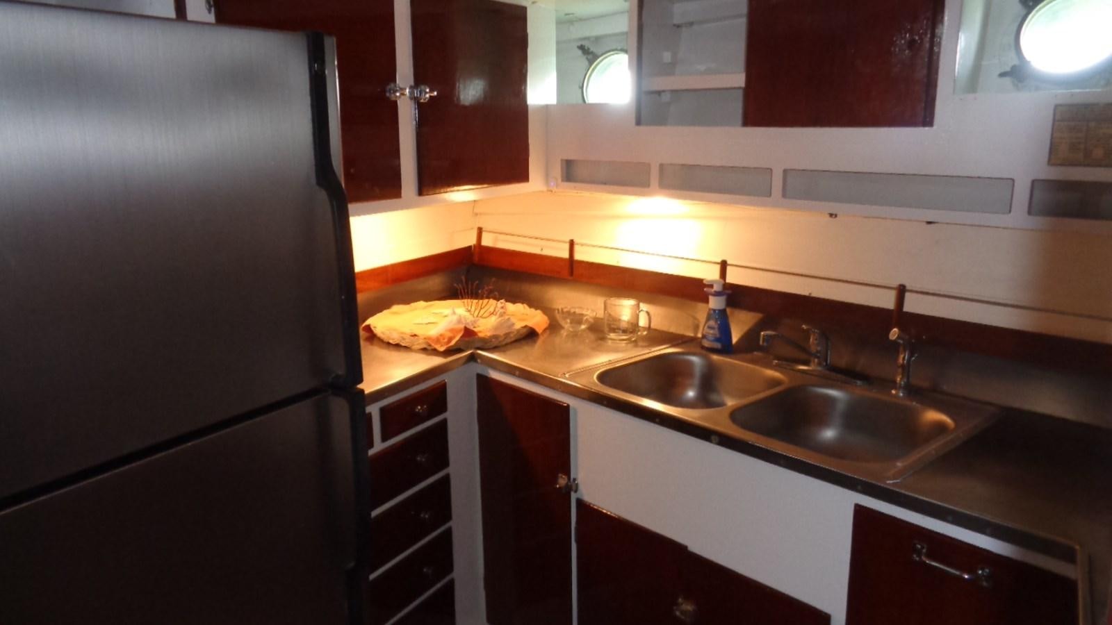a kitchen with a stainless steel refrigerator aboard LION'S WHELP Yacht for Sale