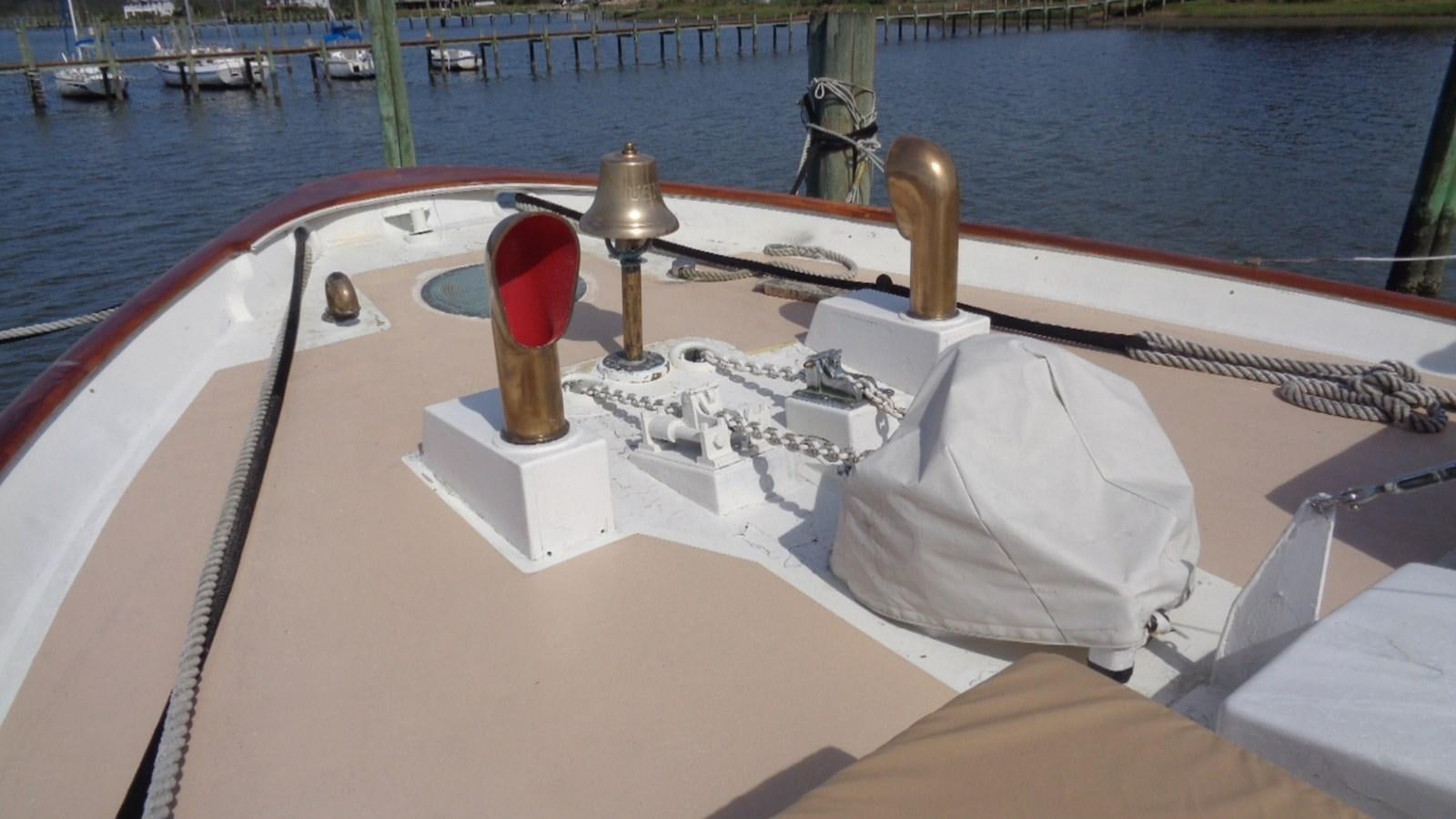 a boat with a white cover and a brown object on the front aboard LION'S WHELP Yacht for Sale
