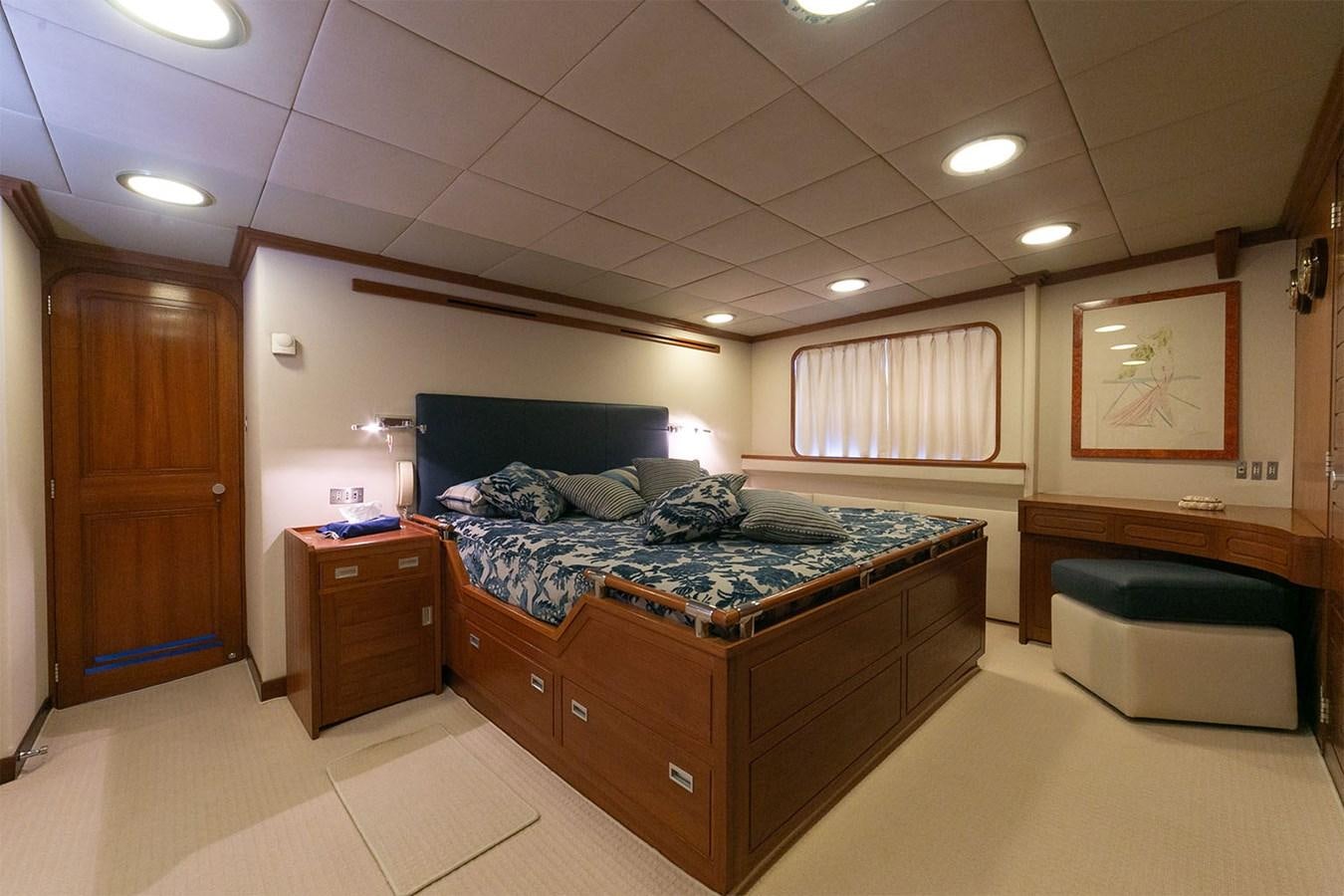 a bedroom with a bed and a desk aboard EMERA Yacht for Sale