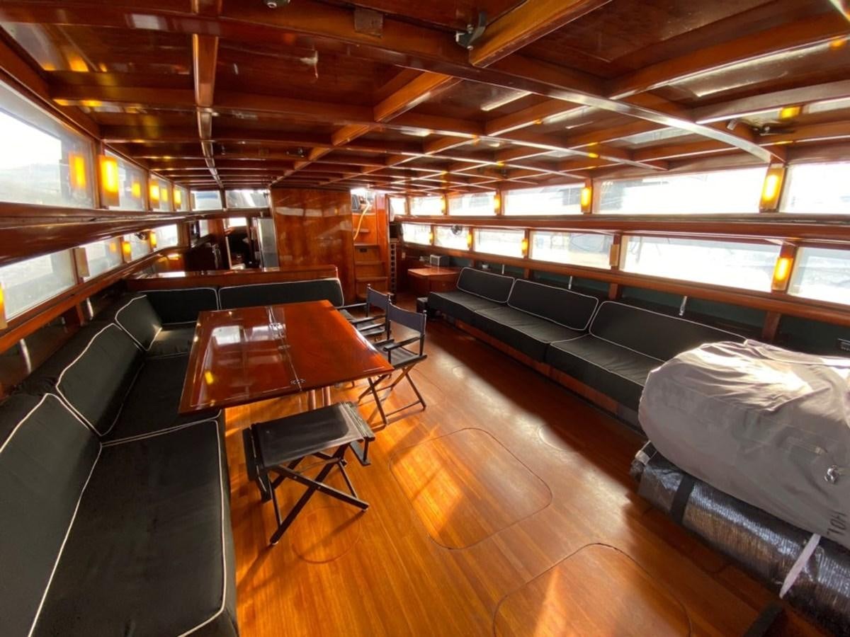 a room with a wood floor and chairs and tables aboard LAUREN L Yacht for Sale