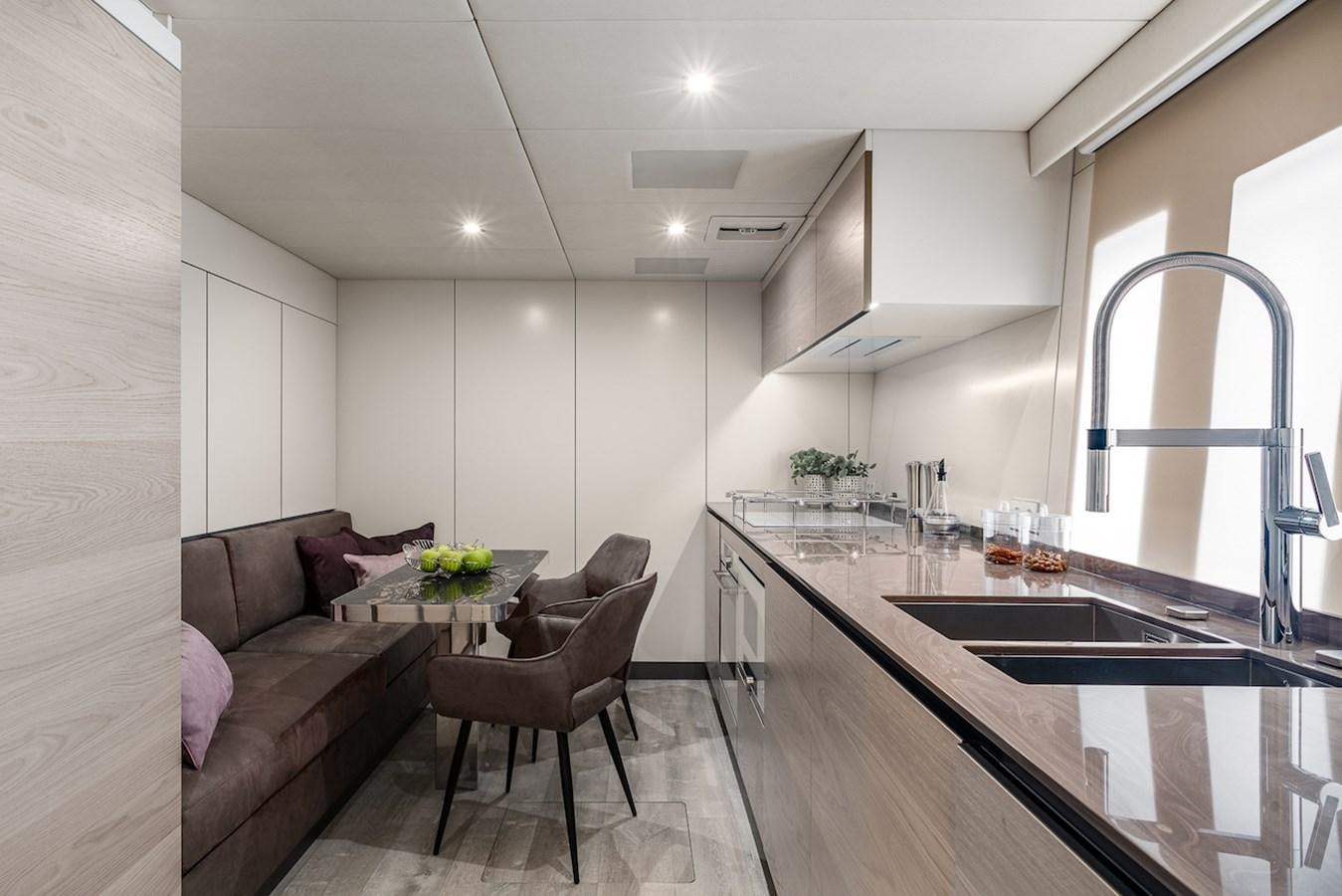 a person sitting on a couch in a kitchen aboard GIJA Yacht for Sale