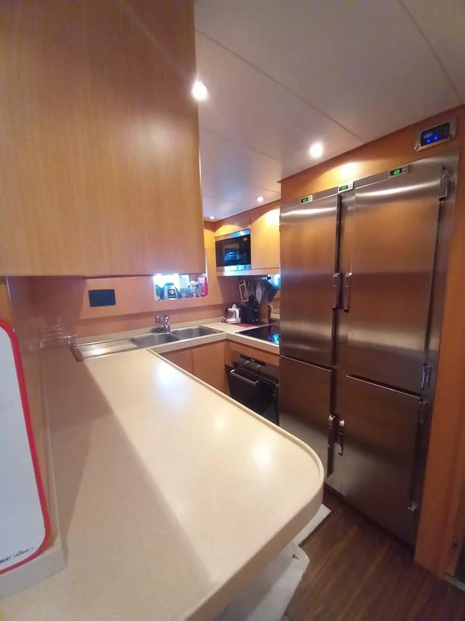 a kitchen with wooden cabinets aboard BRAVO DELTA Yacht for Sale