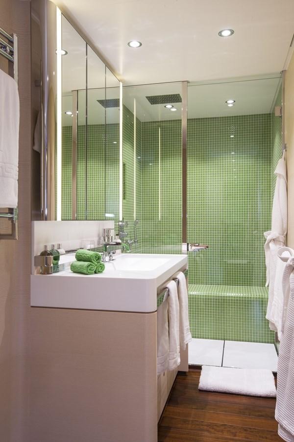 a bathroom with a green shower curtain aboard AQUIJO Yacht for Sale