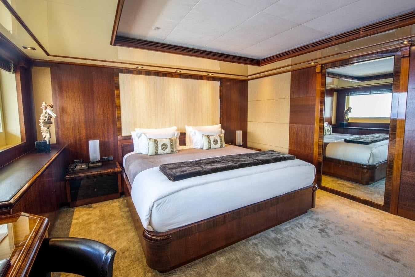 a bedroom with a bed and a mirror aboard ARBEMA Yacht for Charter