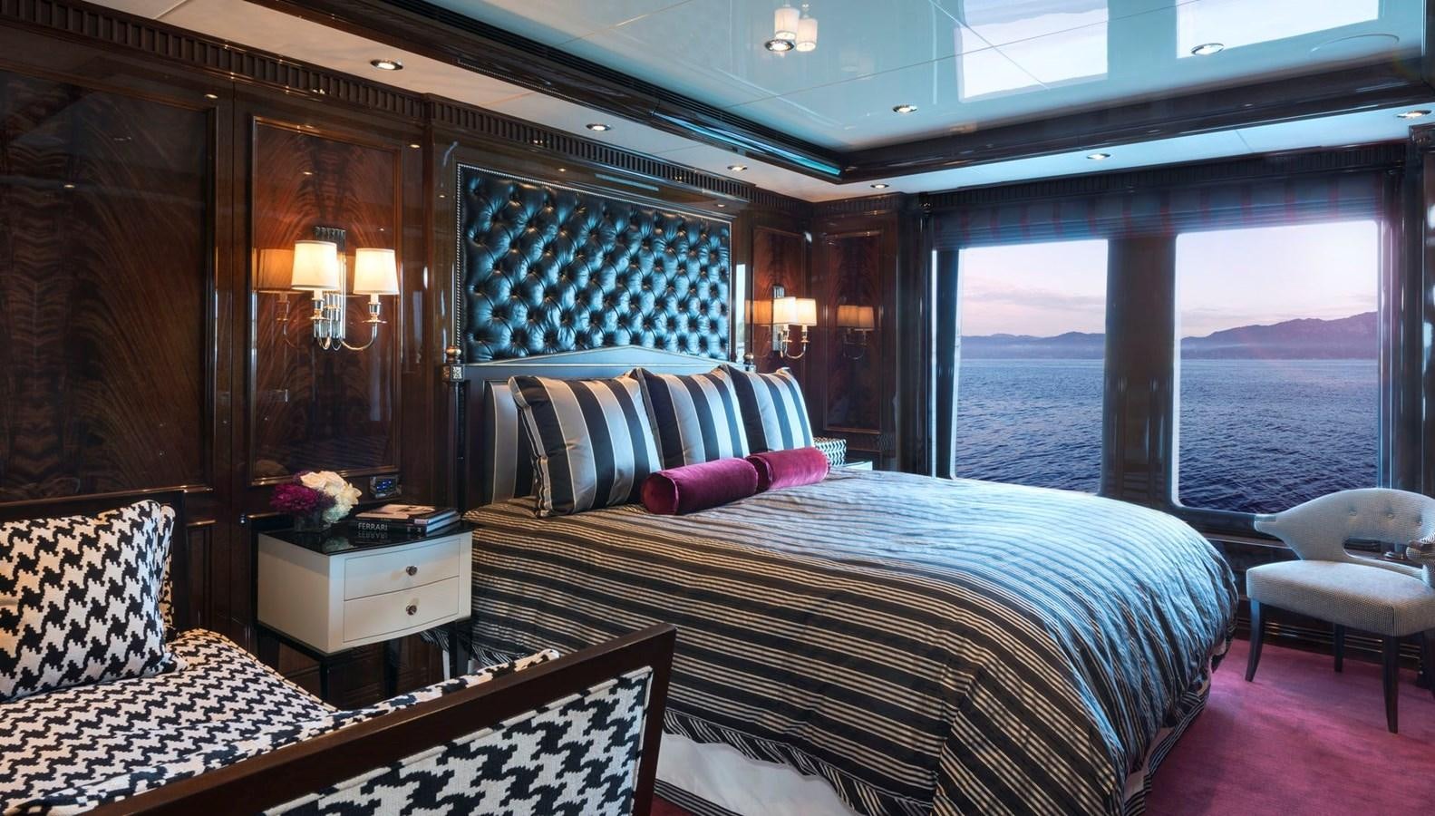 a room with a bed and a view of the ocean aboard INVICTUS Yacht for Sale