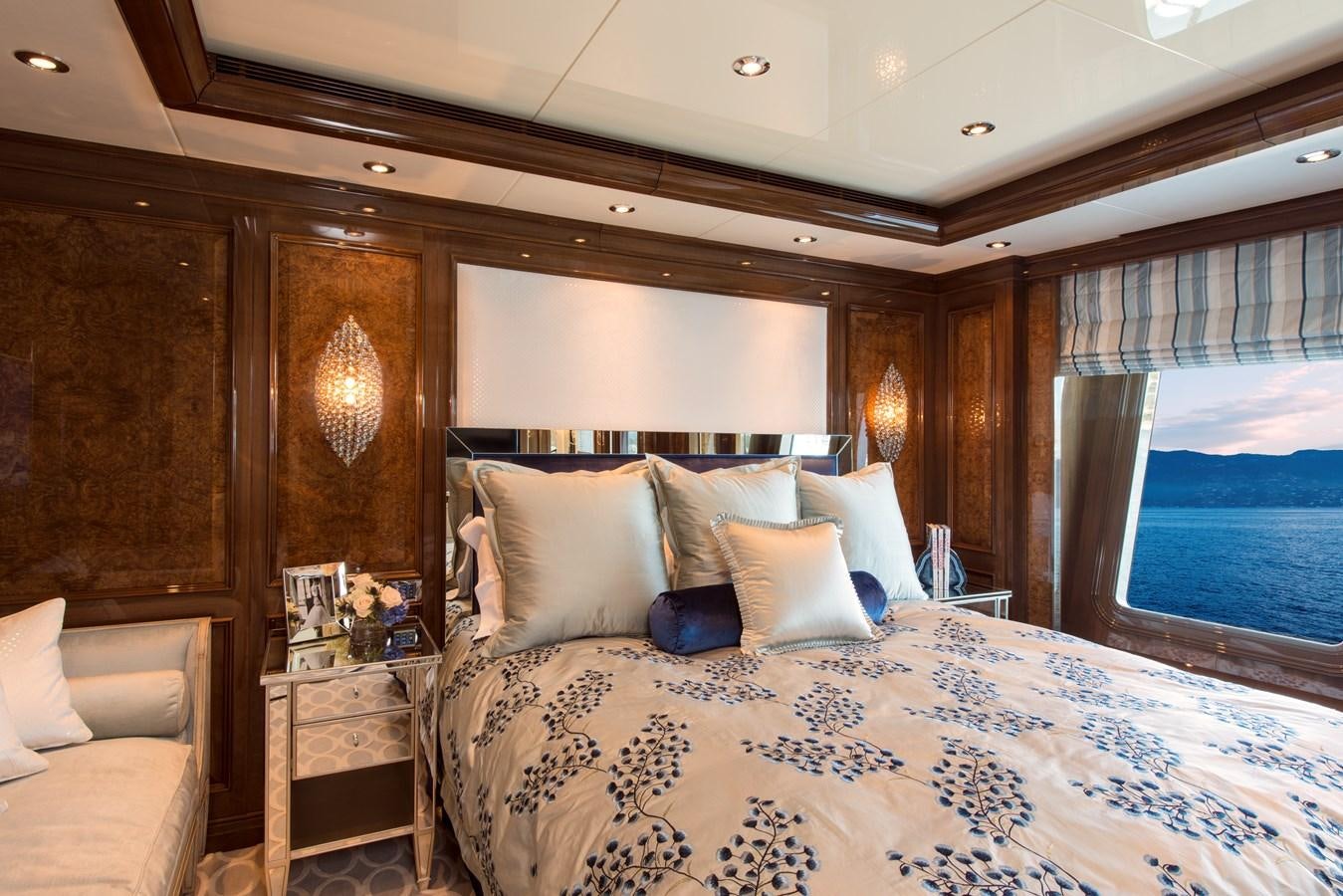 a bed with pillows and a window aboard INVICTUS Yacht for Sale