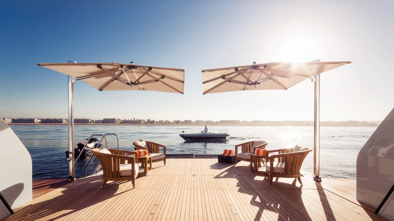 a patio with a table and chairs on it aboard INVICTUS Yacht for Sale