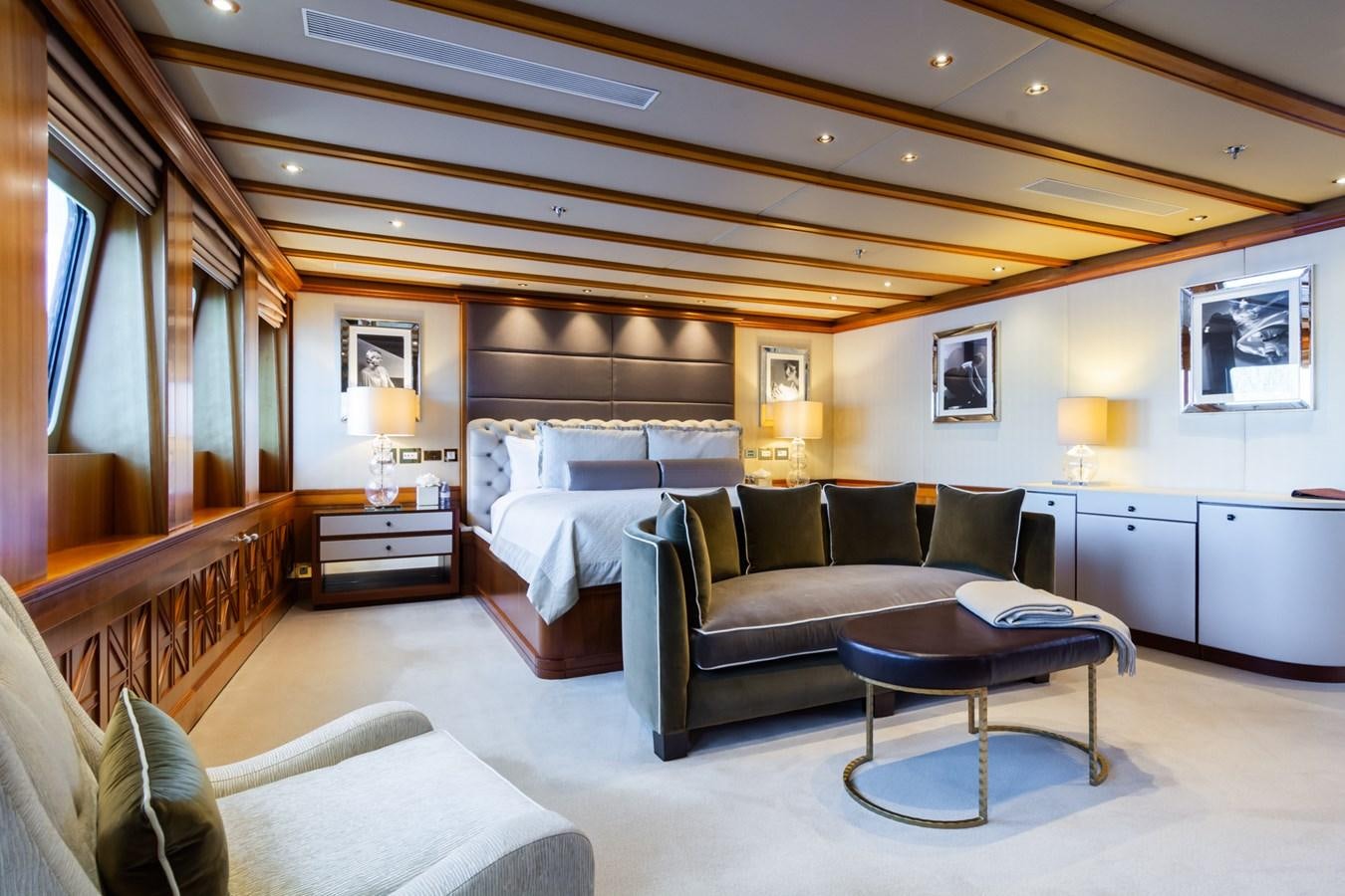 a large bedroom with a bed and a coffee table aboard THE WELLESLEY Yacht for Sale