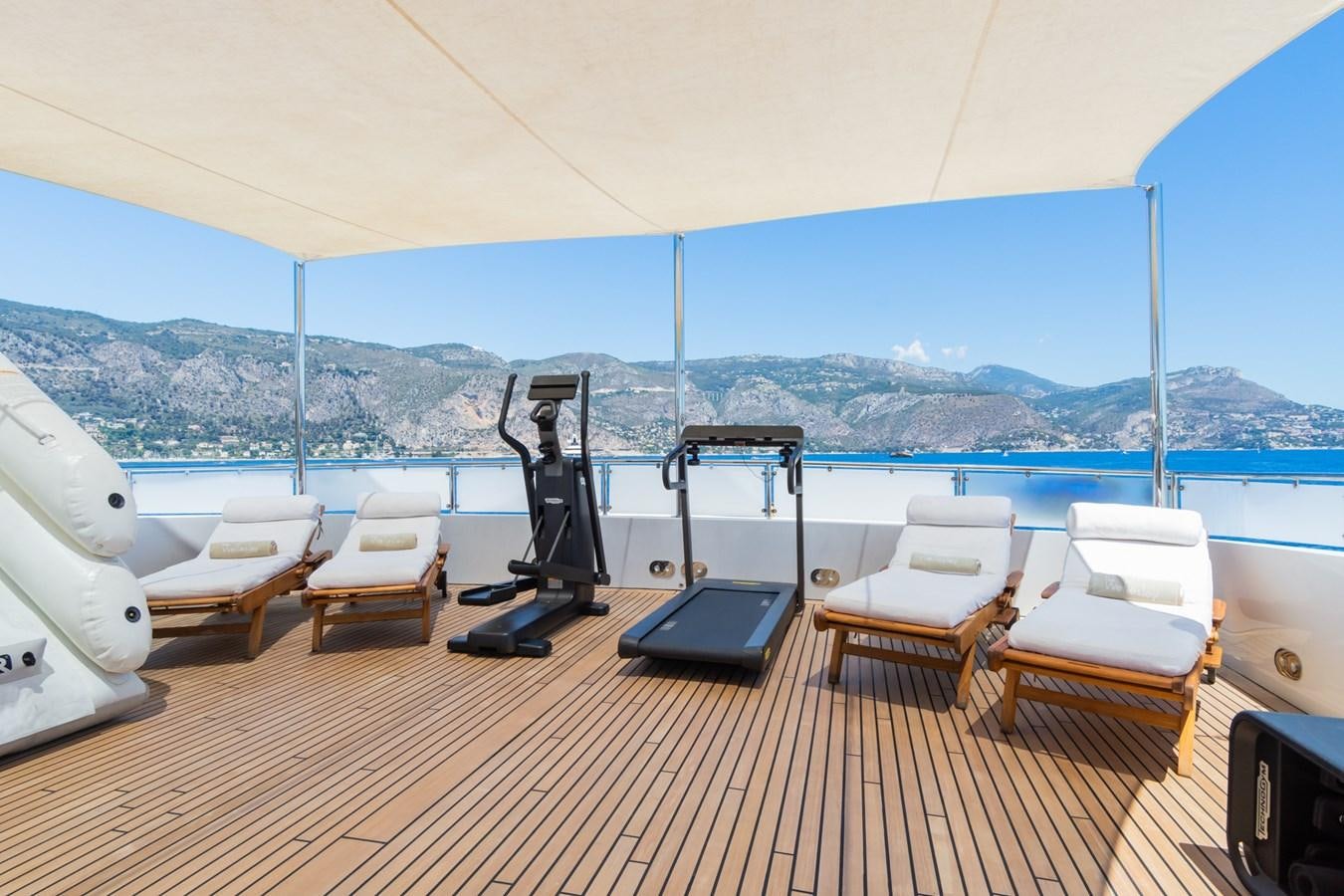 a deck with a laptop and chairs on it aboard THE WELLESLEY Yacht for Sale