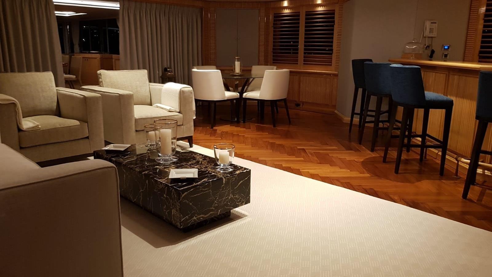 a room with a table chairs and a couch aboard TACANUYA Yacht for Charter