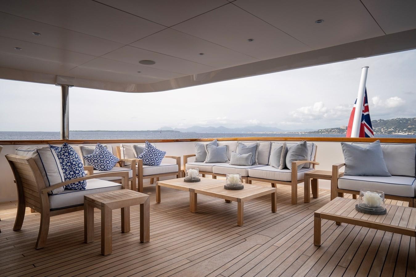 a deck with chairs and a table aboard TACANUYA Yacht for Charter