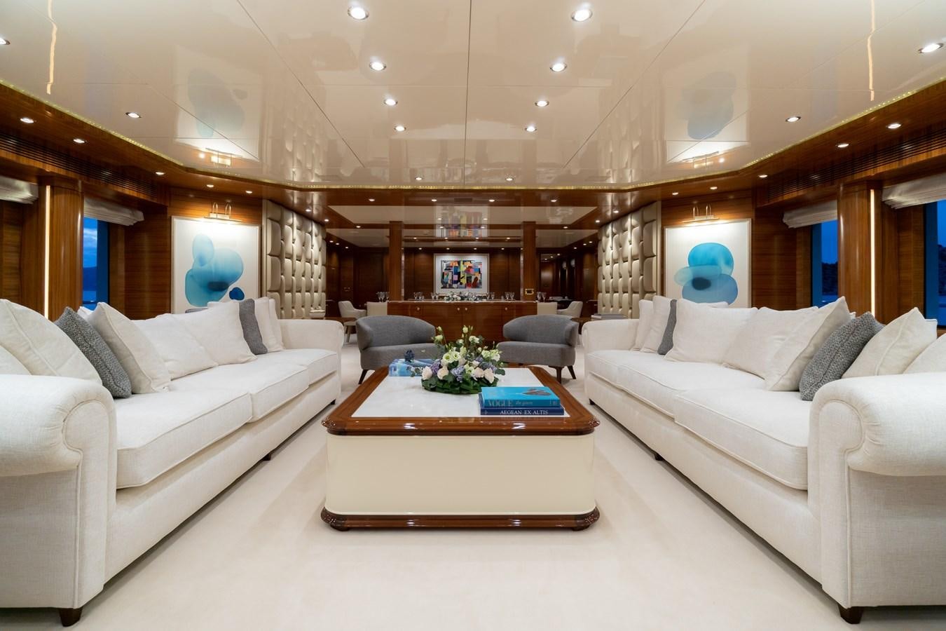 a living room with white couches aboard OCEANOS Yacht for Sale