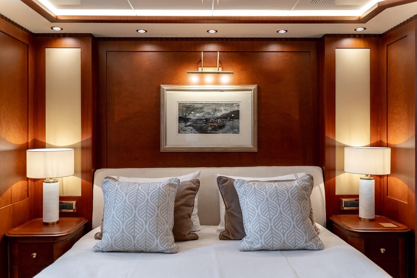 a bed with pillows and lamps aboard OCEANOS Yacht for Sale
