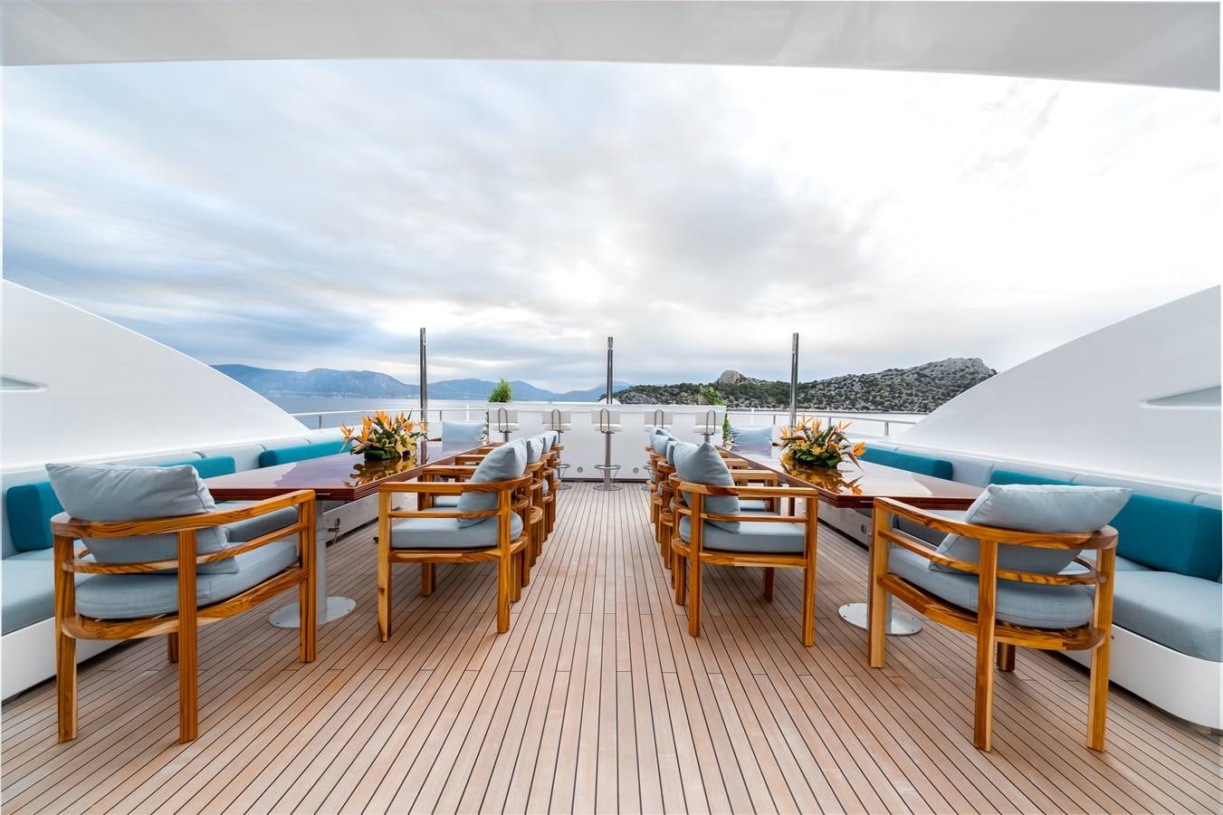 a deck with a table and chairs aboard OCEANOS Yacht for Sale