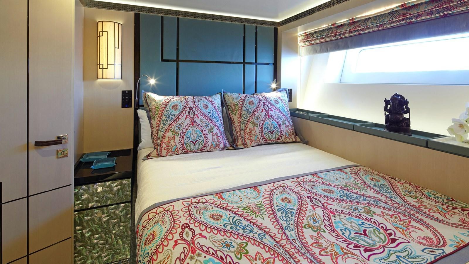 a bed with a blue and white comforter and pillows aboard SAGITTA Yacht for Sale