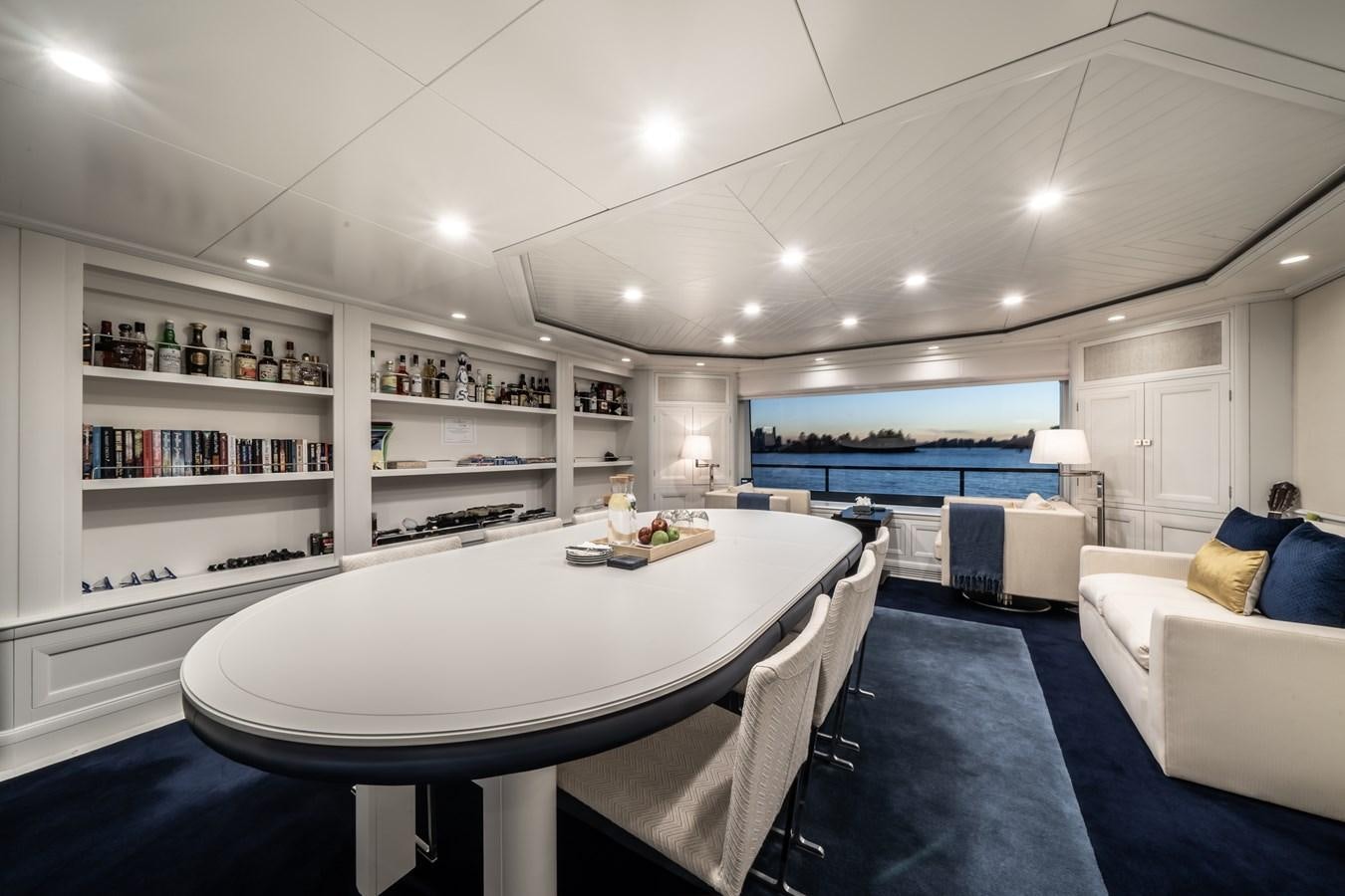 a large white dining table in a room with a large window aboard MOATIZE Yacht for Sale