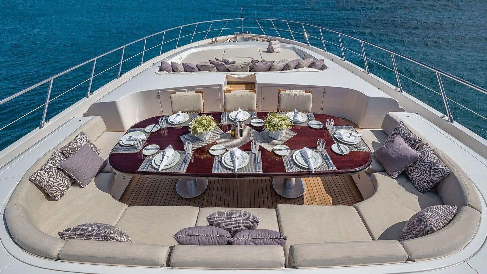 a large white boat with a table and chairs on it aboard JOMAR Yacht for Sale