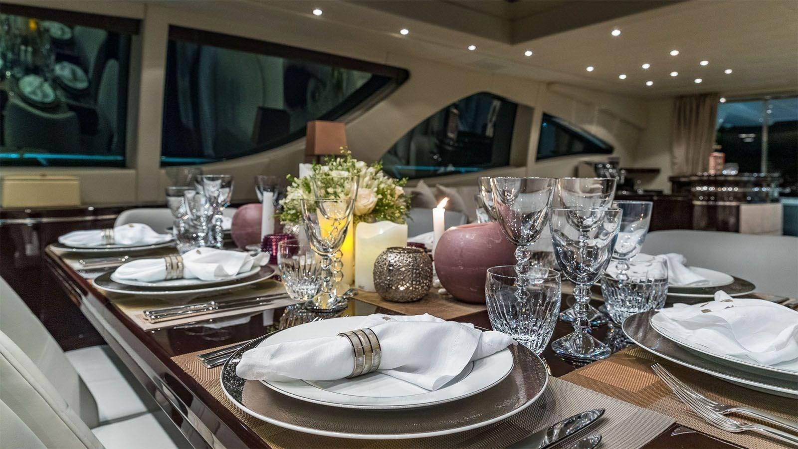 a table with plates and glasses aboard JOMAR Yacht for Sale