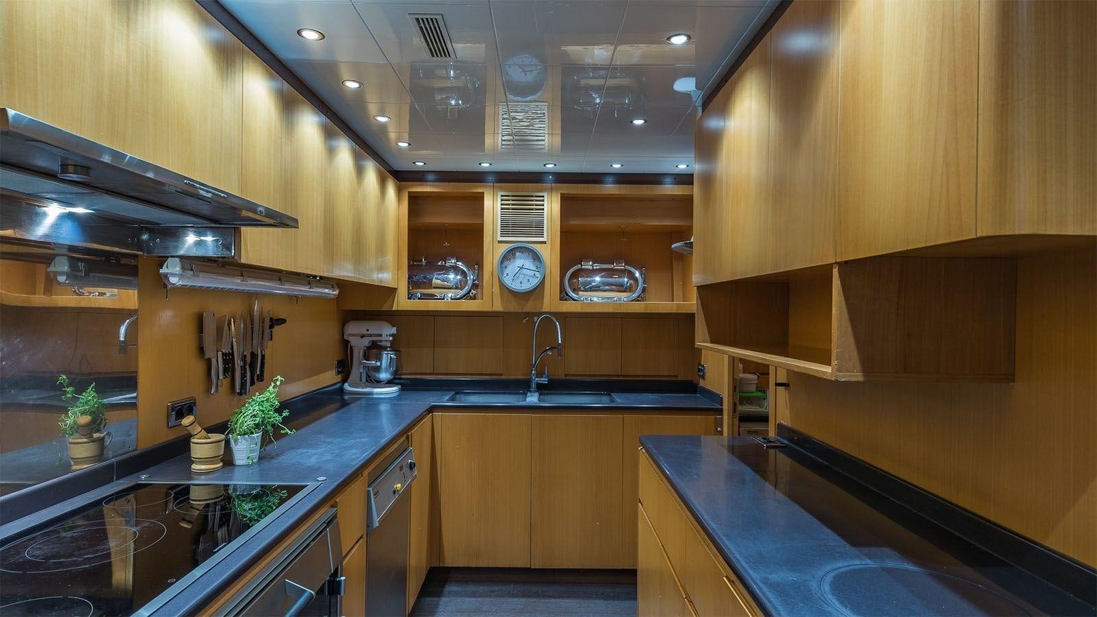 a kitchen with wooden cabinets aboard JOMAR Yacht for Sale
