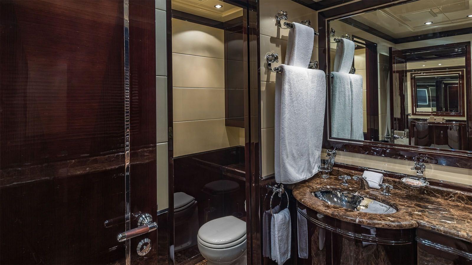 a bathroom with a sink toilet and a mirror aboard JOMAR Yacht for Sale